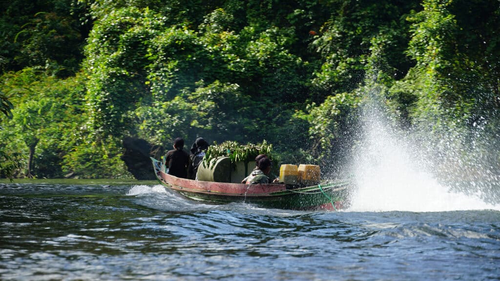 Orang-Utan-Transportkäfige werden über Fluß zum Auswilderungsort transportiert